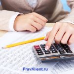 Девушка считает на калькуляторе данные отчетов